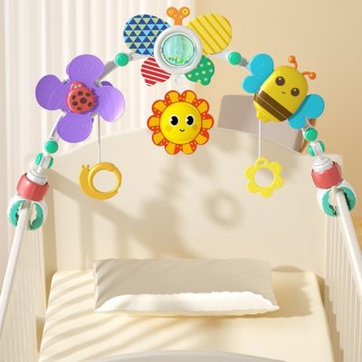 Arc d’activité bébé installé sur un lit ou berceau avec jouets sensoriels suspendus, favorisant l’éveil visuel, la coordination et la motricité fine