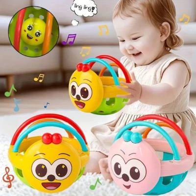 Bébé jouant avec une balle de préhension sensorielle musicale en forme de visage souriant, hochet favorisant l’éveil auditif et la motricité fine