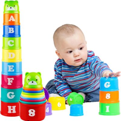 Bébé jouant avec des gobelets empilables Montessori colorés pour apprendre les chiffres, les lettres et développer la motricité fine

