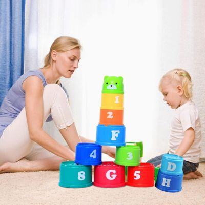 Parent et enfant jouant ensemble avec des gobelets empilables Montessori pour apprendre les chiffres, les lettres et développer la coordination
