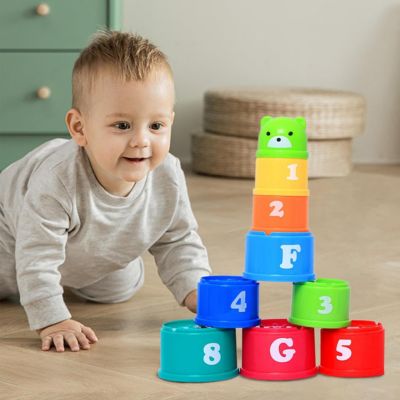 Bébé jouant avec des gobelets empilables Montessori pour développer la motricité fine, la reconnaissance des chiffres et la coordination
