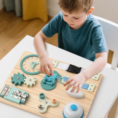 Enfant jouant avec une planche d’activité Montessori en bois type busy board, jouet éducatif favorisant l’autonomie, la motricité fine et l’apprentissage par la manipulation
