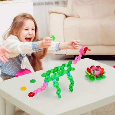 Enfant jouant avec des flocons de construction Montessori SnowiBuild, assemblage de formes colorées favorisant créativité, imagination et motricité fine